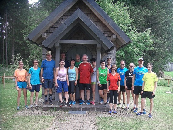 16 Teilnehmer von Lauf10 in Sportkleidung vor der Kapelle im Jungholz